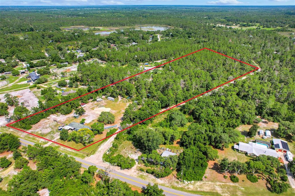 An aerial view shows a rectangular plot of land outlined in red containing a house — 26106 FISHERMANS ROAD, PAISLEY, FL