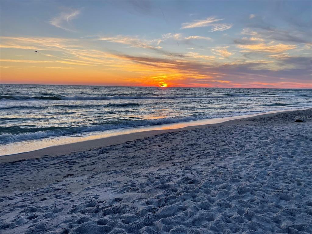 A sunset view over the ocean with waves washing onto a sandy beach — 4621 GULF OF MEXICO DRIVE UNIT 10D, LONGBOAT KEY, FL