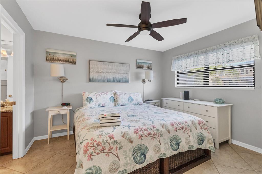 A bedroom features a queen bed with coastal bedding, a ceiling fan, and white furniture — 4621 GULF OF MEXICO DRIVE UNIT 10D, LONGBOAT KEY, FL