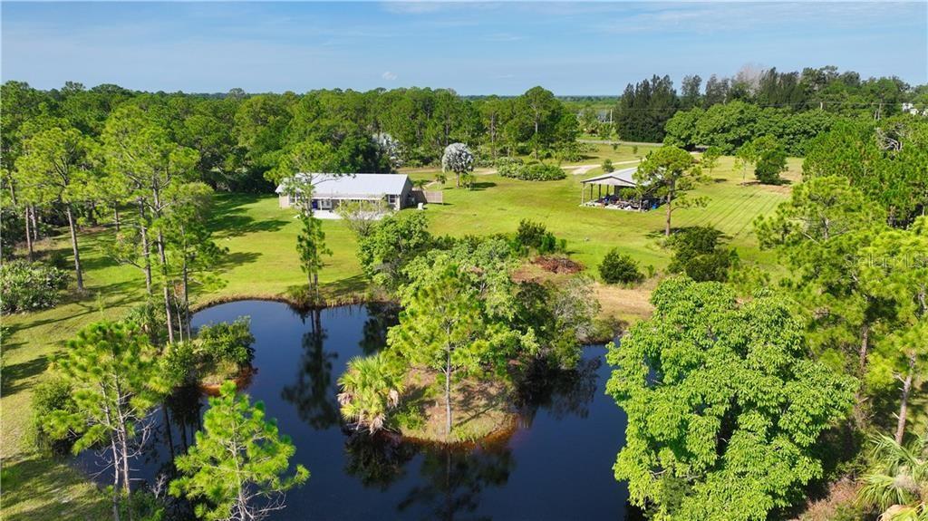 An aerial view of a house and a detached carport situated near a pond — 12050 138TH AVENUE, FELLSMERE, FL