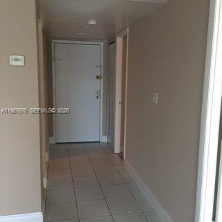 A hallway with light-colored tile flooring leads to a white front door — 488 NW 165th St Rd # 614, Miami FL 33169, MIAMI, FL