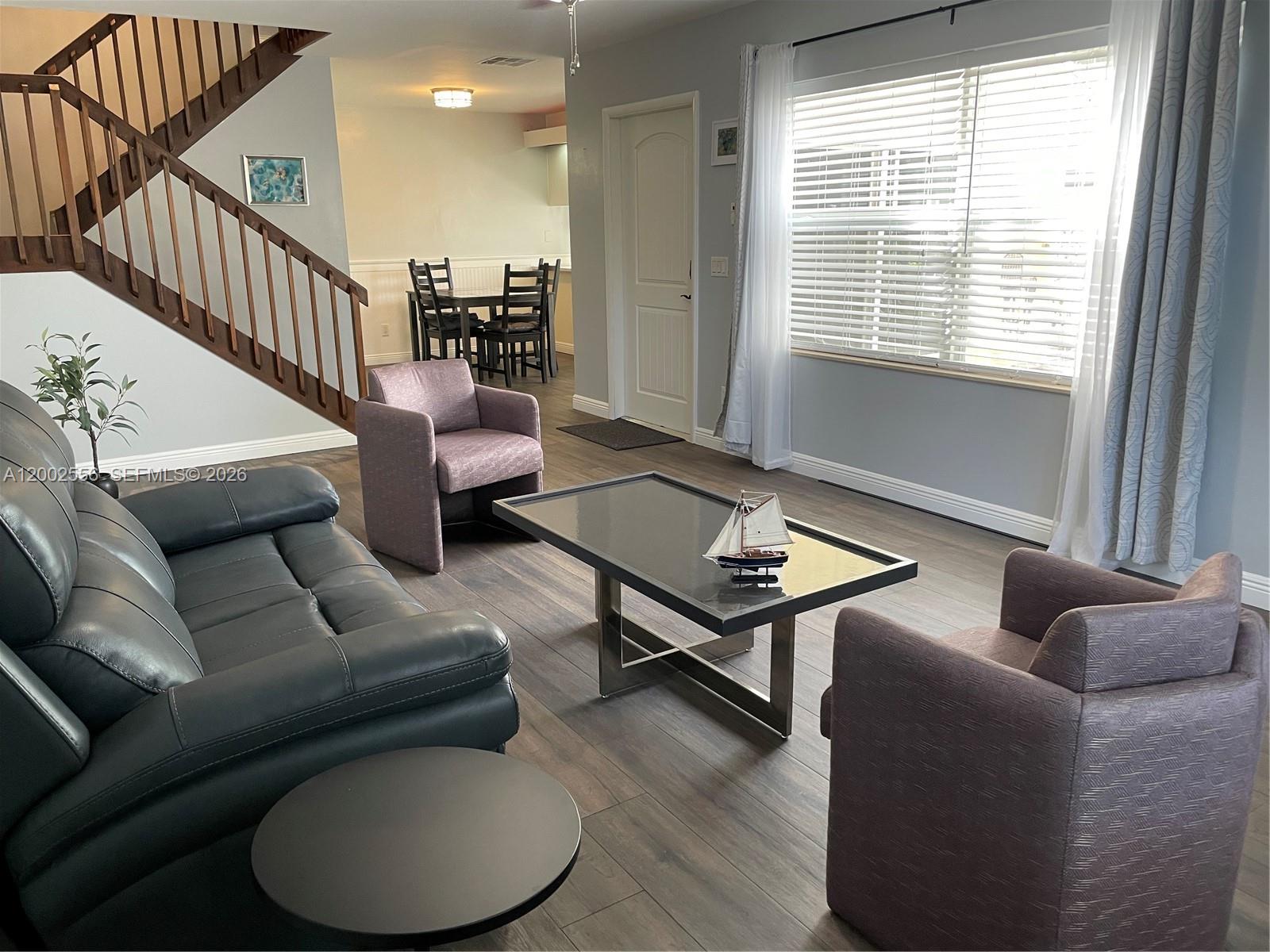A living room features a beige sofa, two armchairs, a coffee table, and a staircase — 5801 Wheatley Ct, Boynton Beach FL 33436, BOYNTON BEACH, FL