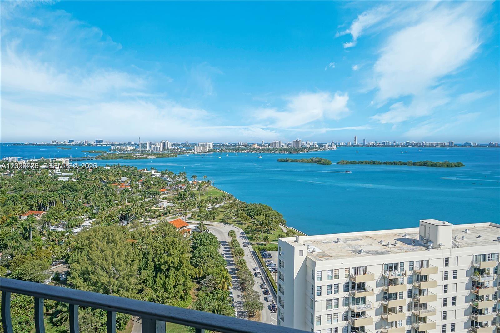An elevated view shows a coastal city skyline across a wide bay with lush greenery — 780 NE 69th St # 2302, Miami FL 33138, MIAMI, FL