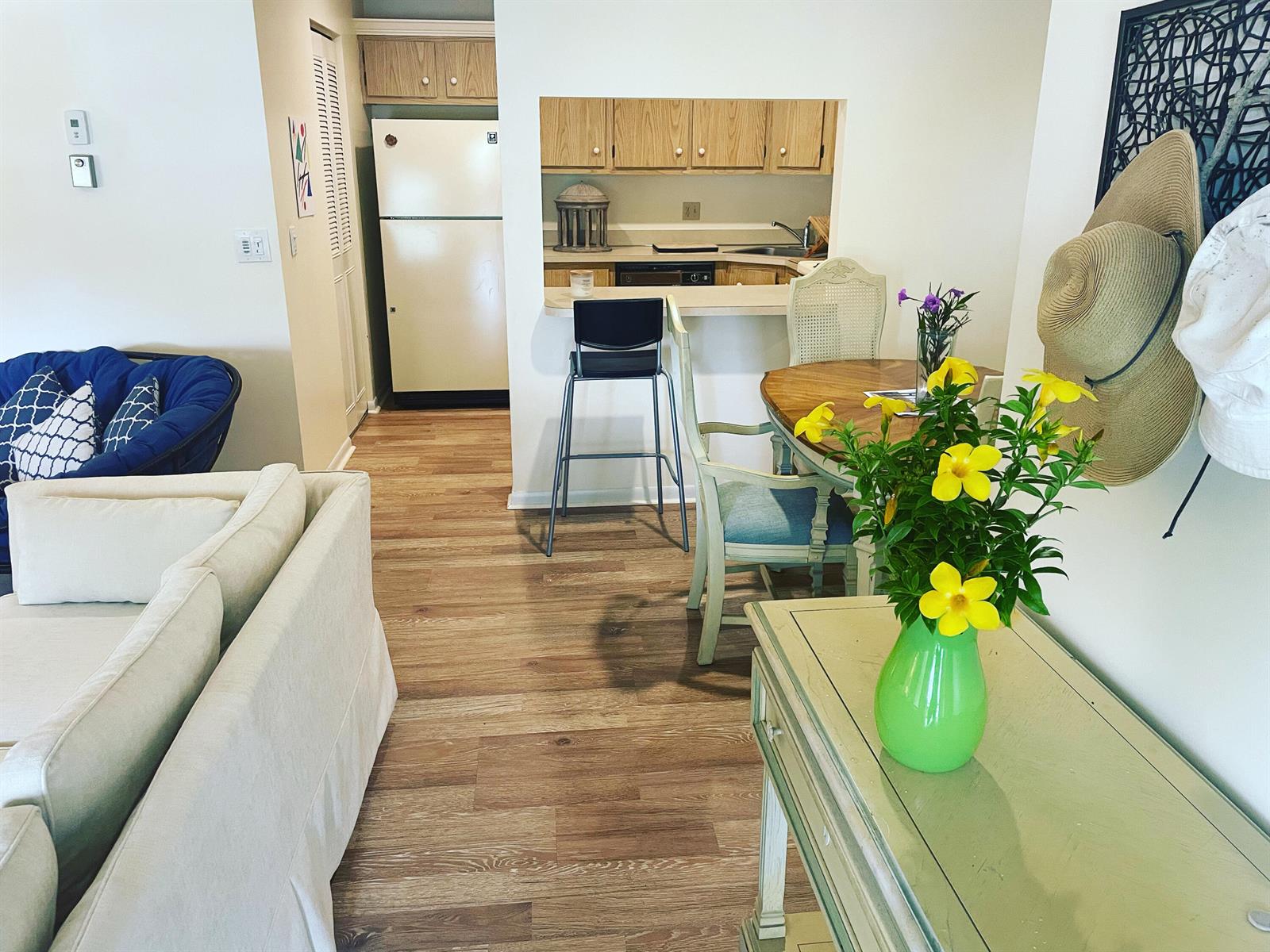 A living area with a sofa, dining table, and a kitchen pass-through with wood cabinets — 519 Shady Pine Way # A2, FL 33415, FL