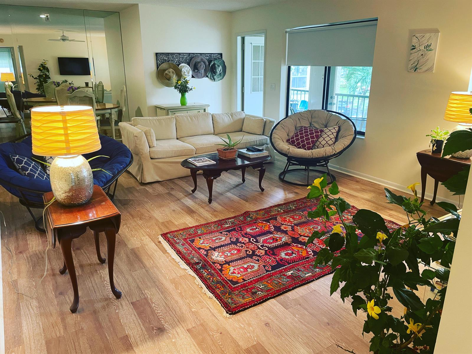 A living room features a beige sofa, two papasan chairs, a patterned rug, and wood flooring — 519 Shady Pine Way # A2, FL 33415, FL