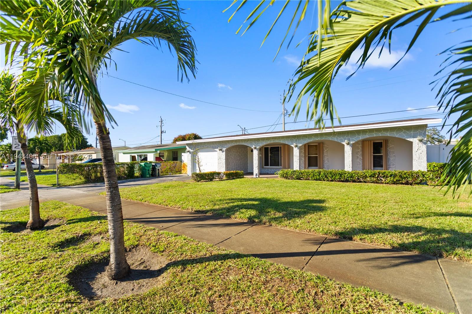 A single-story house with a covered porch and arched columns sits behind a grassy lawn — 3521 NW 18th Pl, Lauderhill FL 33311, LAUDERHILL, FL