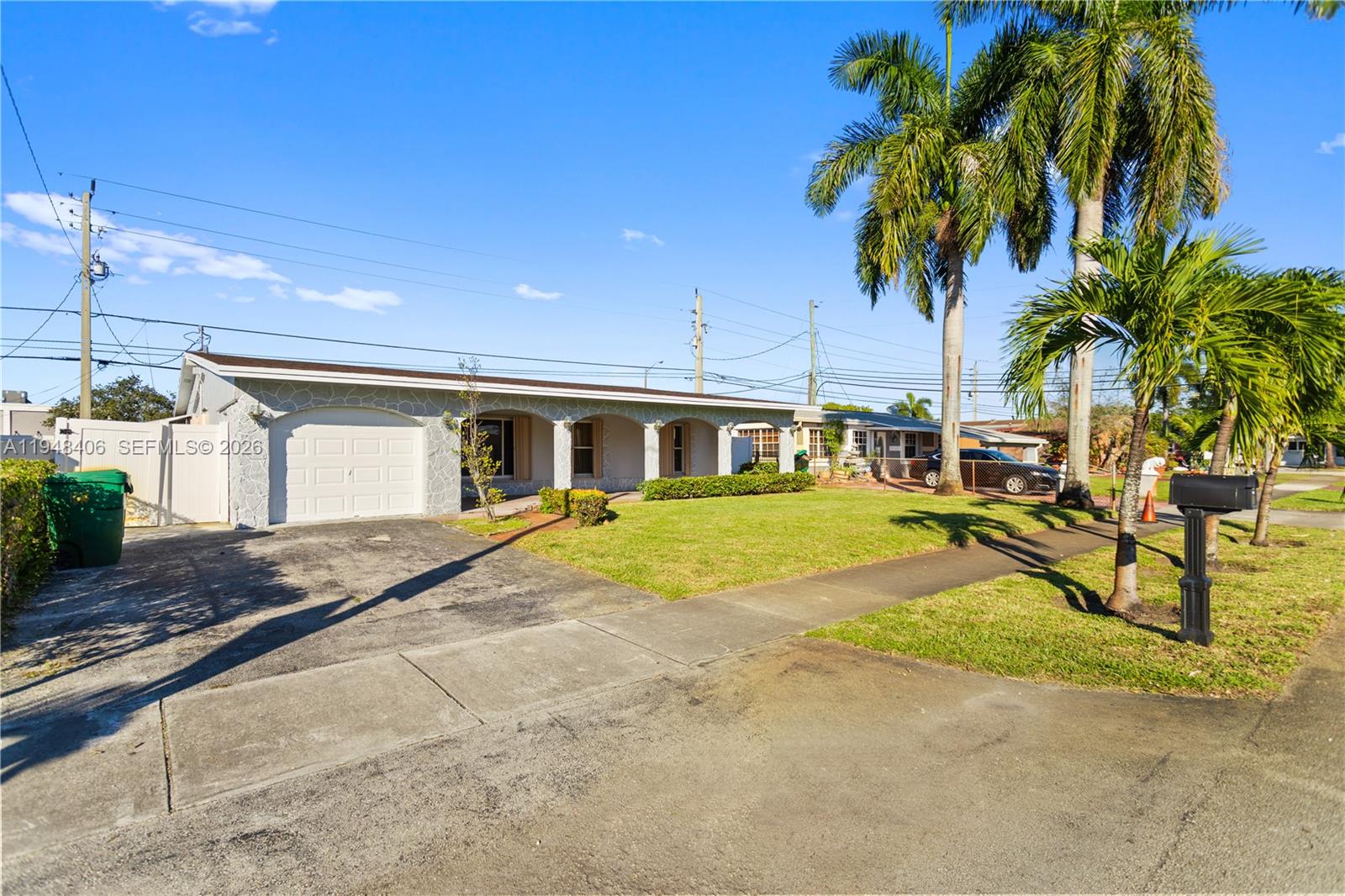 A single-story house with a stone-textured facade, a garage, and palm trees in the yard — 3521 NW 18th Pl, Lauderhill FL 33311, LAUDERHILL, FL