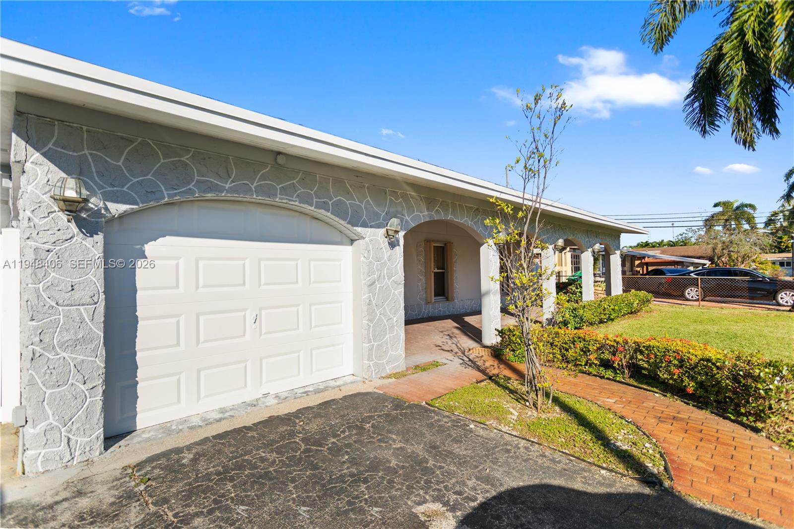 A single-story house features a stone-patterned facade, a white garage door, and a covered porch — 3521 NW 18th Pl, Lauderhill FL 33311, LAUDERHILL, FL