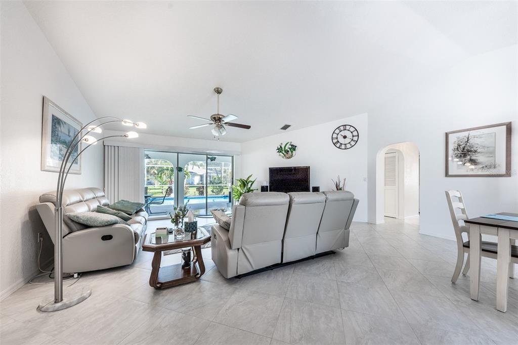 A living room features light gray tile floors, two leather sofas, and a sliding glass door — 538 W CASHEW, PUNTA GORDA, FL