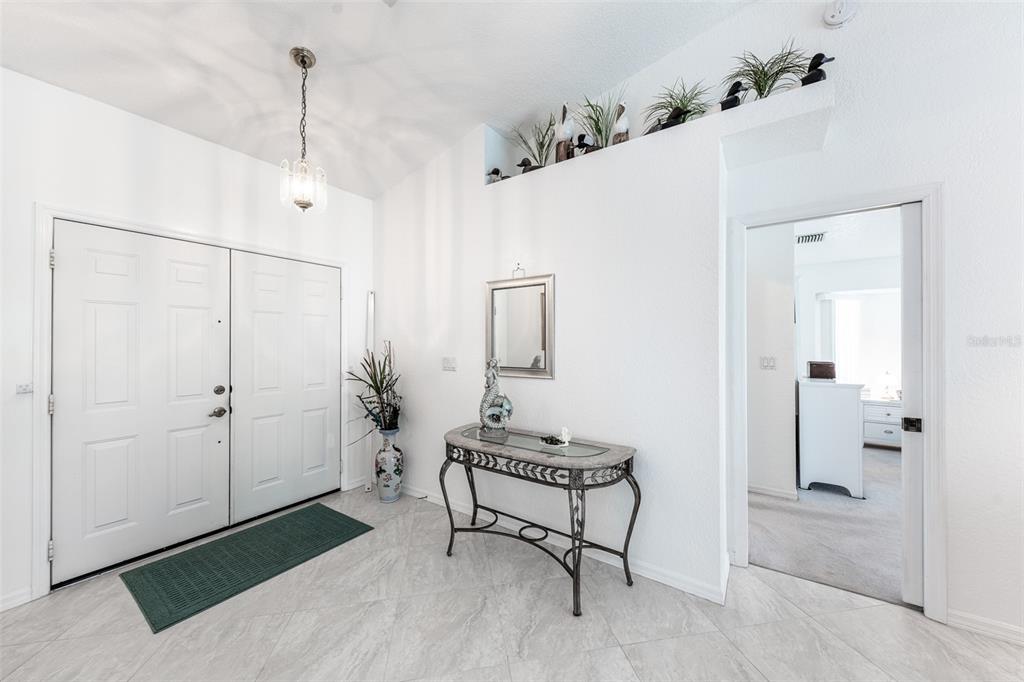 An entryway features white double doors, a glass-topped console table, and a high display ledge — 538 W CASHEW, PUNTA GORDA, FL