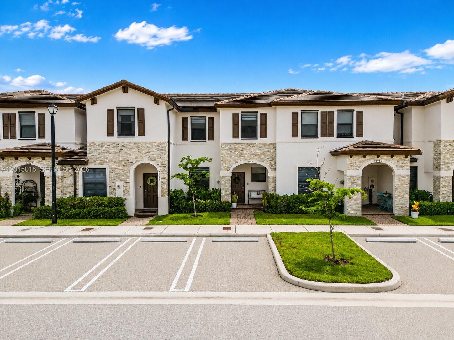 A row of two-story townhouses with stucco and stone facades faces a parking lot — 22961 SW 99th Ave, Cutler Bay FL 33190, CUTLER BAY, FL