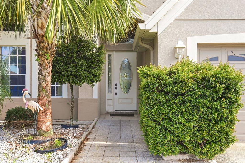 The exterior of a house features a front door, a walkway, and a large hedge — 1357 DARNABY WAY, ORLANDO, FL