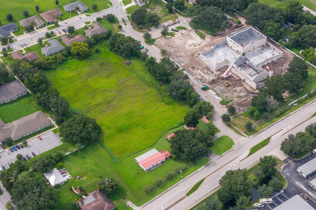 An aerial view shows a large grassy lot, a house, and a building under construction — 3720 KATHLEEN ROAD, LAKELAND, FL