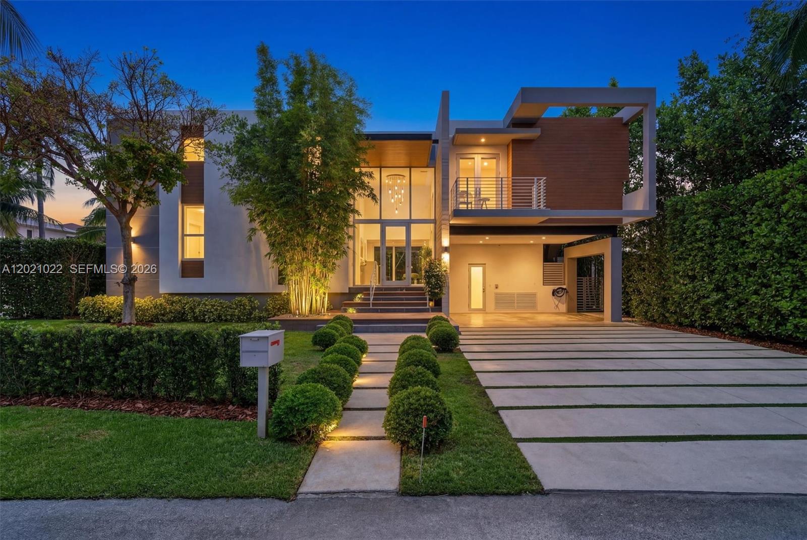 A modern two-story house features a glass entryway, a balcony, and a paved driveway — 625 Curtiswood Dr, Key Biscayne FL 33149, KEY BISCAYNE, FL