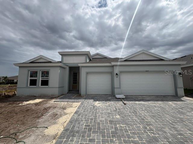 A modern kitchen features white cabinetry, a large quartz island, and light wood-look flooring — 5237 WOLF CREEK DRIVE, APOLLO BEACH, FL