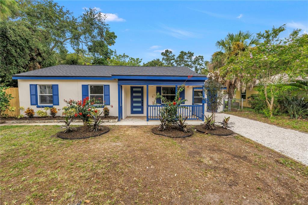 A single-story house with a blue-trimmed porch, white siding, and a gravel driveway — 8171 37TH AVENUE N, ST PETERSBURG, FL