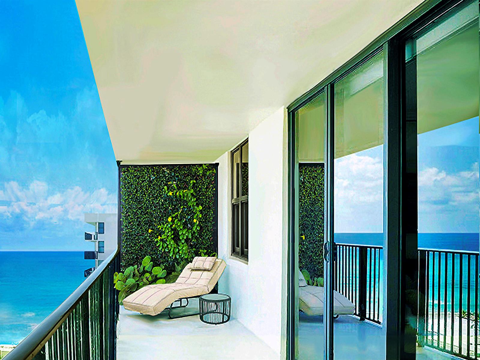 A balcony with a lounge chair, a small table, and a green wall overlooking the ocean — 3460 S Ocean Boulevard # 7110, Palm Beach FL 33480, PALM BEACH, FL