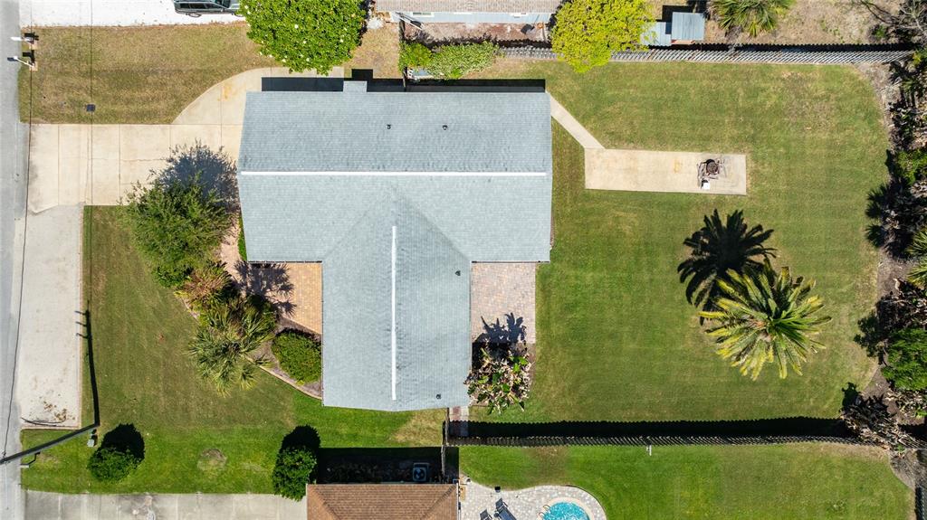 An aerial view shows a house with a gray roof, a driveway, and a backyard — 40 CUNNINGHAM DRIVE, NEW SMYRNA BEACH, FL