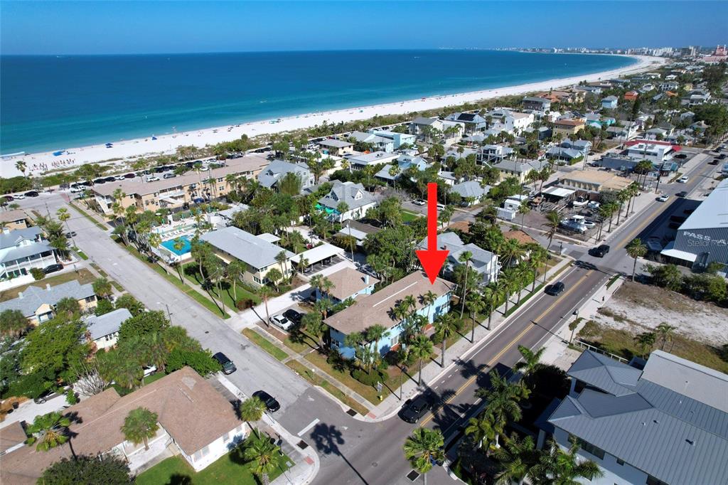 An aerial view shows a blue two-story building near a beach and coastal road — 1800 PASS-A-GRILLE WAY UNIT 2, ST PETE BEACH, FL