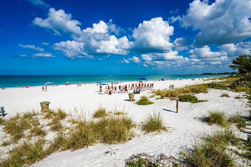 A wide, sandy beach features a group of people exercising under a bright blue sky — 1800 PASS-A-GRILLE WAY UNIT 2, ST PETE BEACH, FL