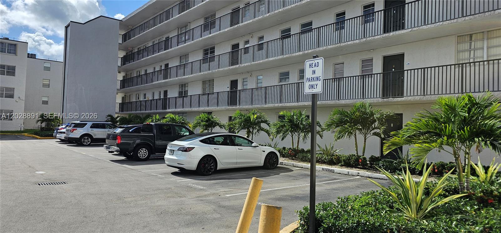 A multi-story apartment building exterior features a parking lot with several parked cars — 14170 SW 84th St # F, Miami FL 33183, MIAMI, FL