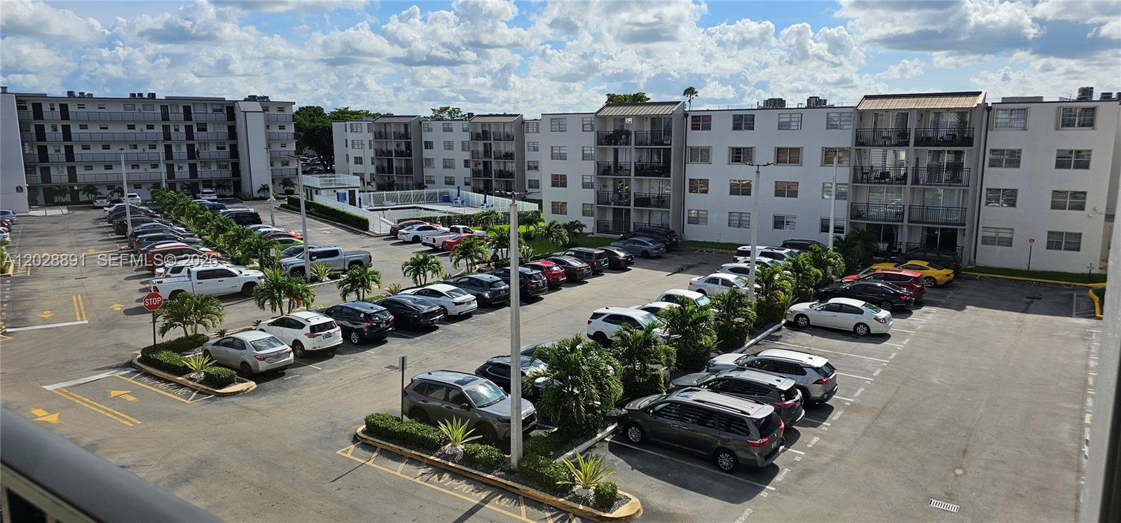 An aerial view shows a large apartment complex parking lot filled with many parked cars — 14170 SW 84th St # F, Miami FL 33183, MIAMI, FL