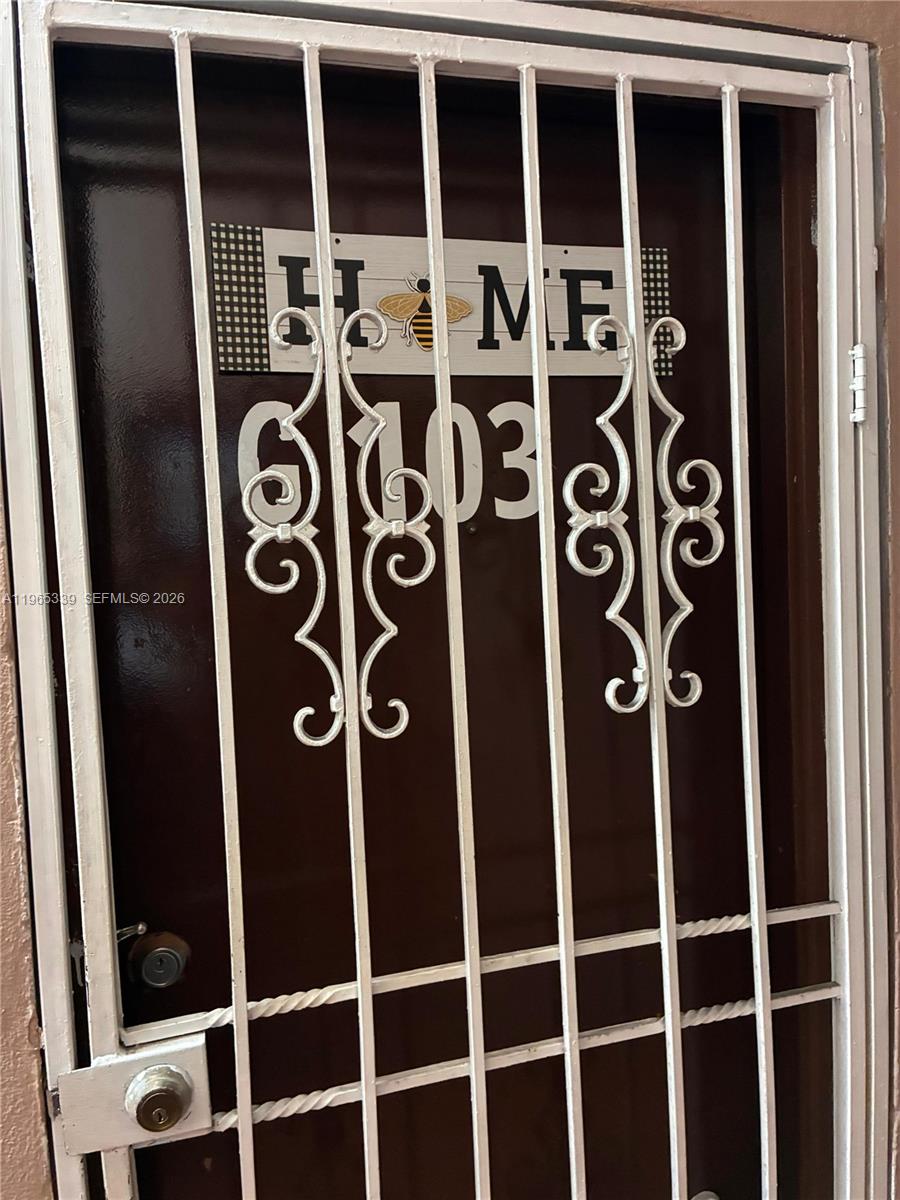 A brown door with a white metal security gate displays the number 6103 — 1900 W 68th St # G103, Hialeah FL 33014, HIALEAH, FL