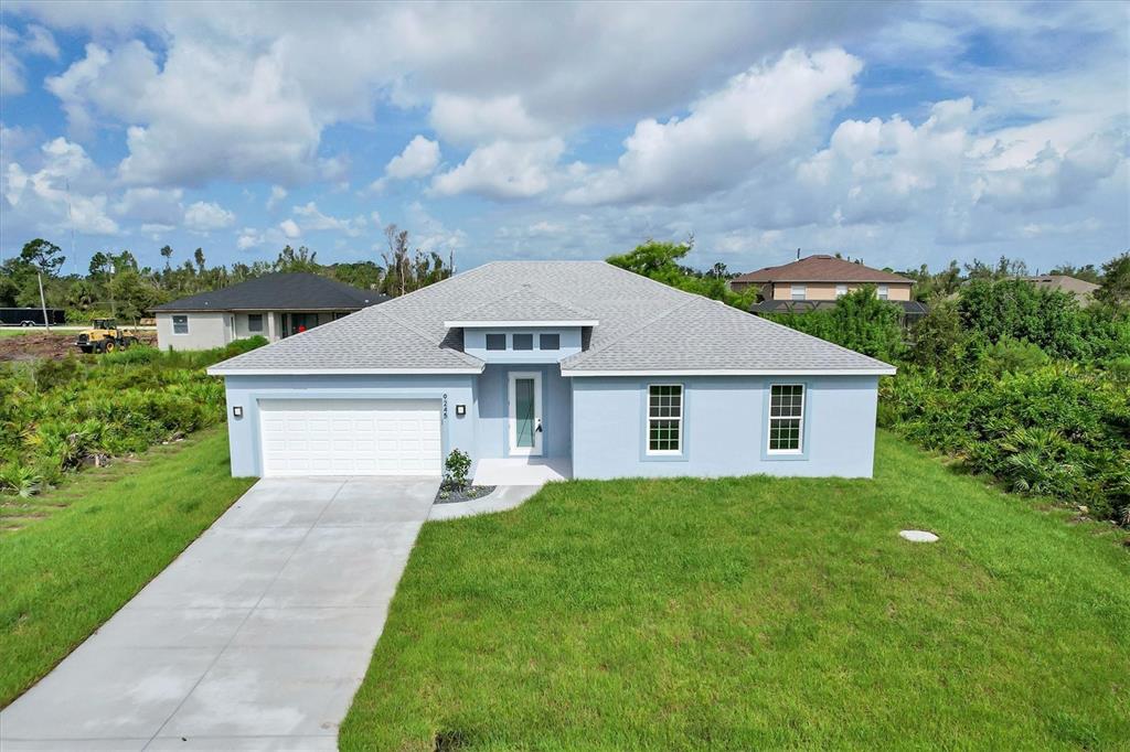 A light blue single-story house with a gray shingled roof and a concrete driveway — 9245 ZORN STREET, PORT CHARLOTTE, FL