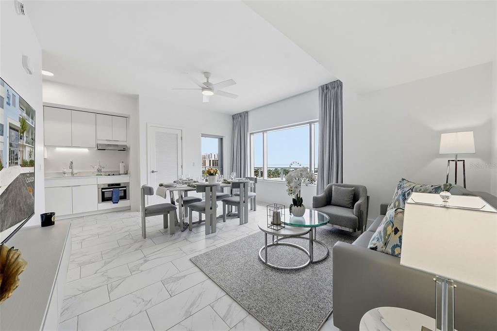 A modern open-concept living and dining area features white cabinetry, marble-look tile, and large windows — 411 E SHORE DRIVE UNIT 403, CLEARWATER BEACH, FL