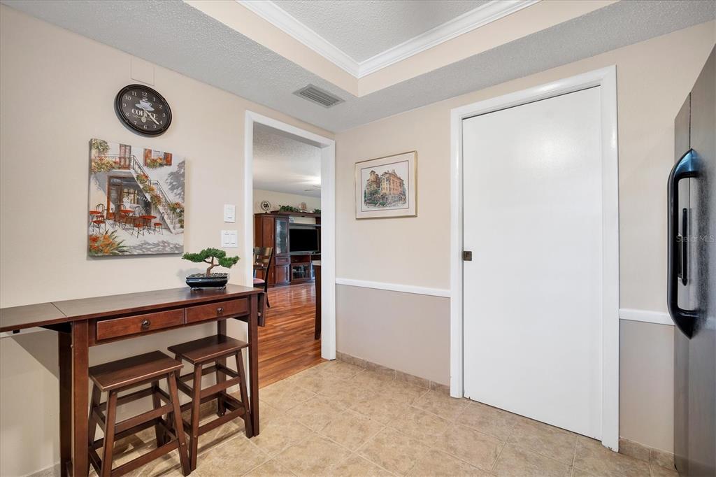 A kitchen area features a small wooden table with two stools, tile flooring, and a doorway — 5032 MARSHFIELD ROAD UNIT 19, SARASOTA, FL