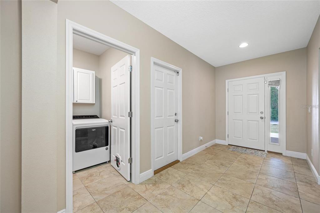 A tiled entryway features a white front door, a laundry room, and a side door — 230 CLAYTON STREET, BRANDON, FL