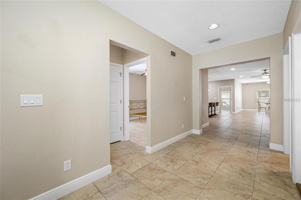A tiled hallway leads to an open living area with a view of a bedroom — 230 CLAYTON STREET, BRANDON, FL