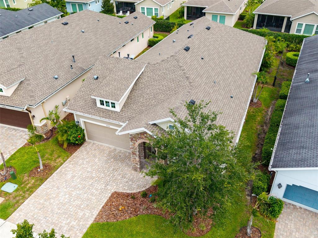 An aerial view shows a suburban house with a shingled roof and paved driveway — 14008 SWALLOW HILL DRIVE, LITHIA, FL