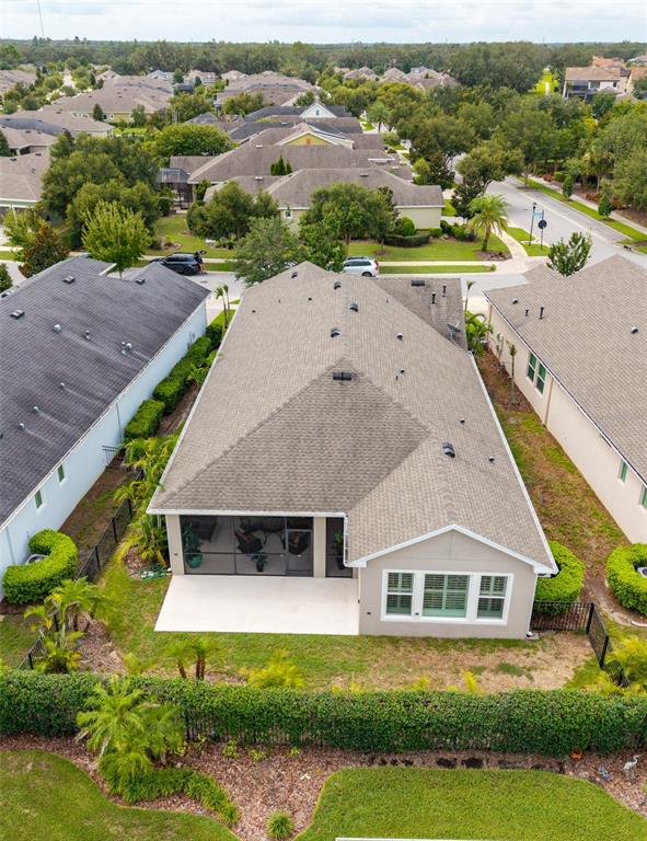 An aerial view shows a suburban house with a screened-in patio and a fenced backyard — 14008 SWALLOW HILL DRIVE, LITHIA, FL