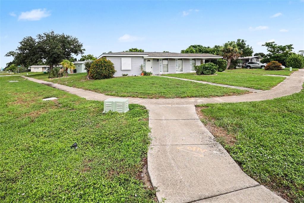 A single-story gray house with a concrete walkway leading to the front entrance — 21422 MALLORY AVENUE, PORT CHARLOTTE, FL