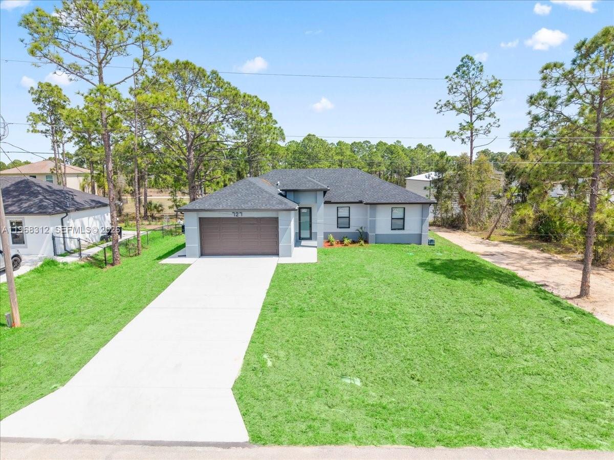 A single-story house with a gray exterior, a brown garage door, and a concrete driveway — 727 Drury Ave, Lehigh Acres FL 33974, LEHIGH ACRES, FL