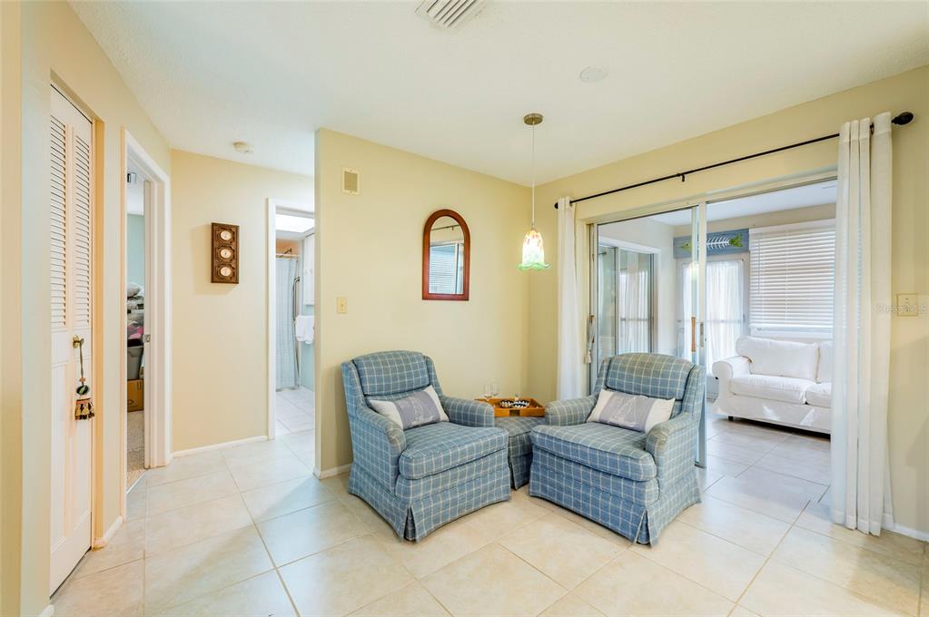 A room with two blue plaid armchairs, a small table, and a sliding glass door — 4479 MICHIGAN LANE, CLEARWATER, FL