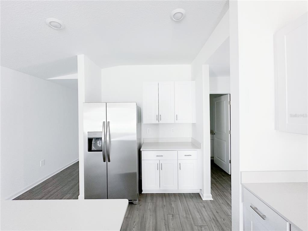 A white pantry with wire shelving sits next to a closed door and a vent — 8414 SW 41 CIRCLE, OCALA, FL
