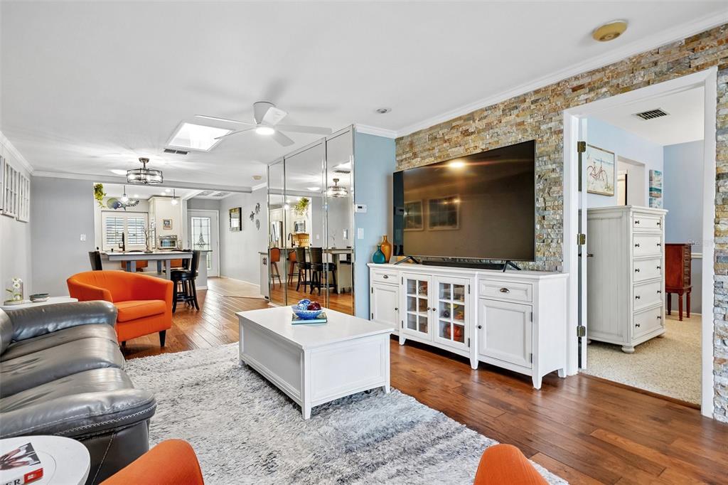 A home office features hardwood floors, a desk with multiple monitors, and a ceiling fan — 3259 HILARY CIRCLE UNIT 1C, PALM HARBOR, FL