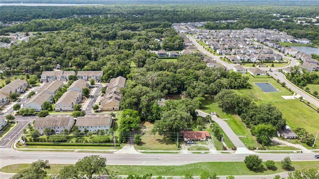 An aerial view shows a residential neighborhood with townhomes, a single-story house, and surrounding trees — 0000 N RONALD REAGAN BLVD, SANFORD, FL