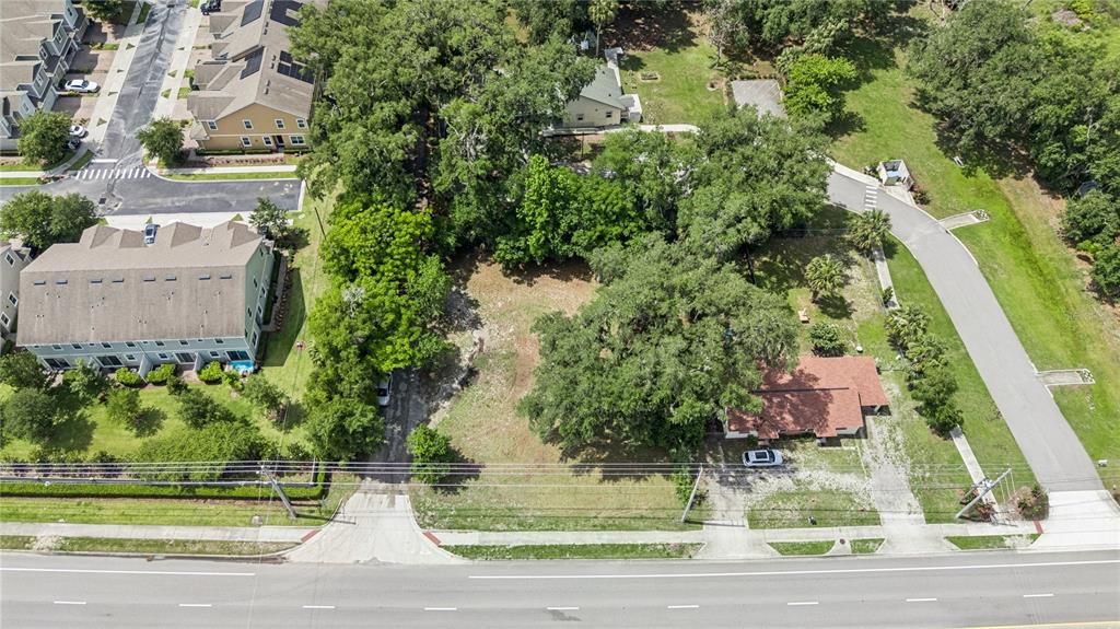 An aerial view shows a vacant lot situated between a residential complex and a house — 0000 N RONALD REAGAN BLVD, SANFORD, FL