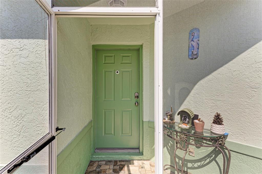 A green front door is visible through an open screen door on a covered porch — 3009 LIVE OAK LANE, PALMETTO, FL