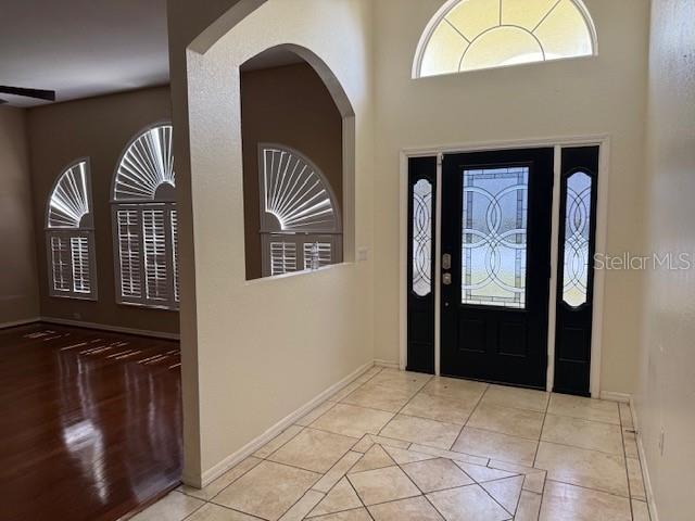 An entryway with tile flooring, a dark front door, and an arched wall opening — 302 STERLING DRIVE, WINTER HAVEN, FL