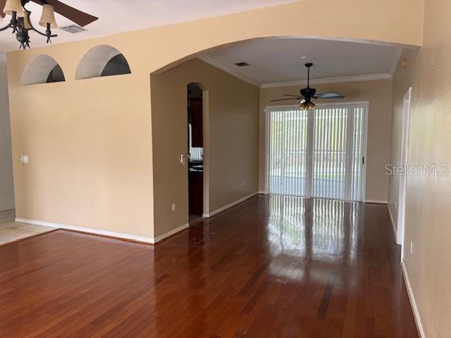 An open living area features hardwood floors, an arched entryway, and a ceiling fan — 302 STERLING DRIVE, WINTER HAVEN, FL