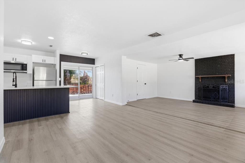 A backyard features a swimming pool, a patio with lounge chairs, and a white house — 113 EASTWAY DR, LAKELAND, FL