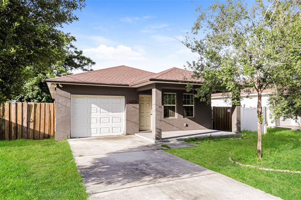 A single-story house with a brown stucco exterior, a one-car garage, and a front porch — 1505 E CARACAS STREET, TAMPA, FL