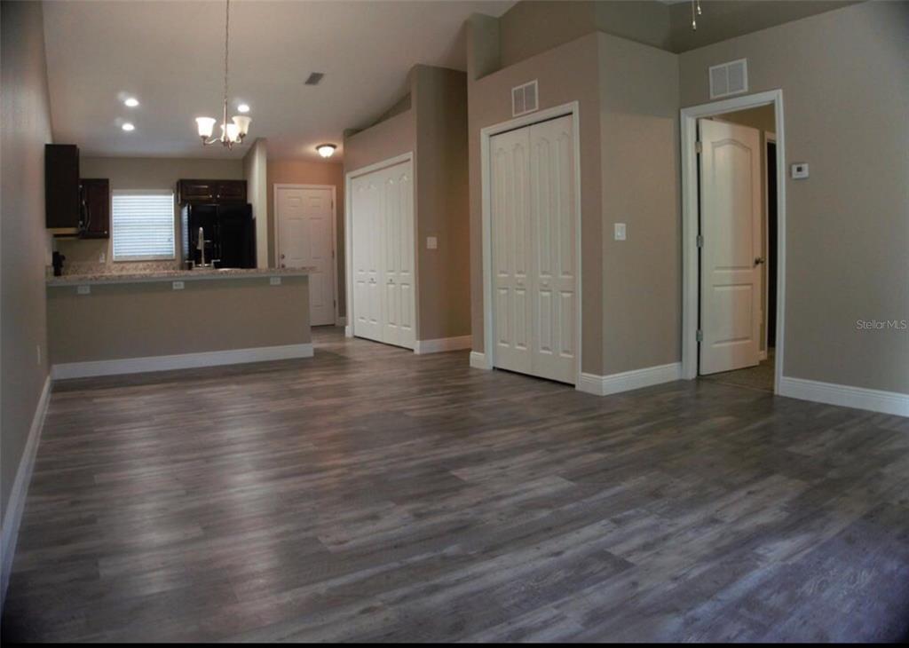 A backyard patio features a sliding glass door, a white vinyl fence, and lawn — 9288 N MENDOZA WAY, CITRUS SPRINGS, FL