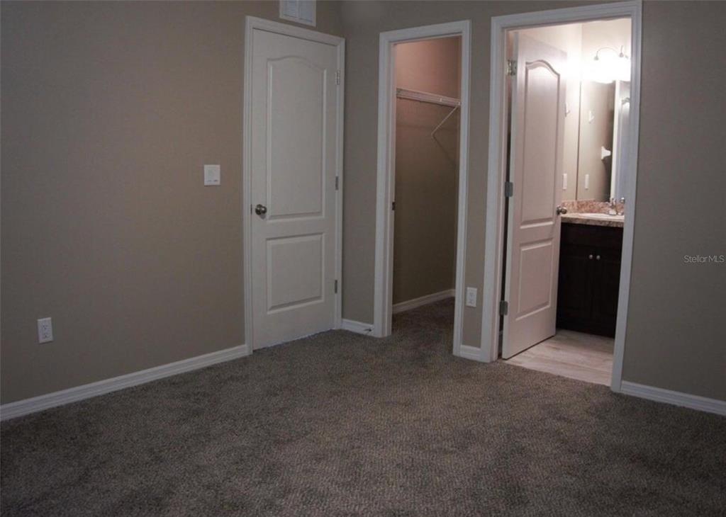 A kitchen features dark wood cabinets, black appliances, light countertops, and wood-look flooring — 9288 N MENDOZA WAY, CITRUS SPRINGS, FL