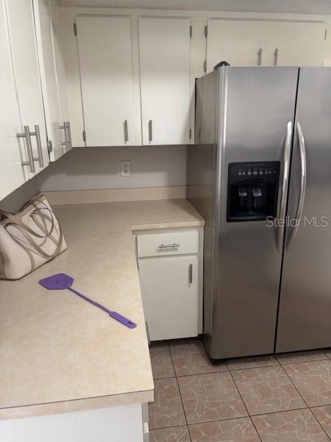 A kitchen features white cabinets, a stainless steel refrigerator, and a light-colored countertop — 10405 SW 98TH TERRACE, OCALA, FL