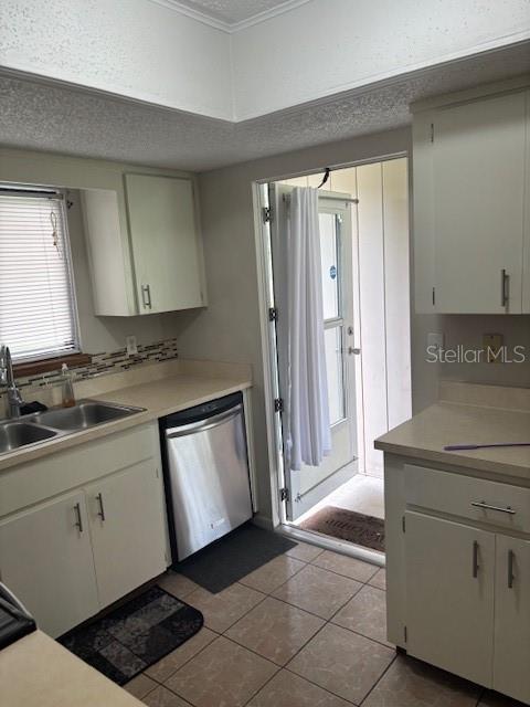 A kitchen with light-colored cabinets, a stainless steel dishwasher, and a door leading outside — 10405 SW 98TH TERRACE, OCALA, FL